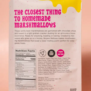 A standing pouch of MOJAVE MALLOWS - S’MORE SPECKLED MARSHMALLOWS by MOJAVE MALLOWS, showcasing bold pink and yellow lettering with playful graphics on a cream background. The packaging emphasizes these organic s’more marshmallows—decadent chocolate chip treats dusted with graham cracker, ideal for anyone seeking artisanal marshmallows with a unique twist.