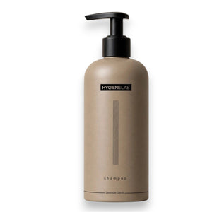 A beige bottle of HYGIENELAB - SHAMPOO, LAVENDER SANDS features a black pump dispenser, minimalist vertical lines, and the scent “Lavender Sands” indicated at the bottom.