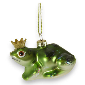 The CODY FOSTER HERALDLY FROG ORNAMENT features a shiny green finish, glittery gold crown, and gold hanging string—a whimsical decor piece perfect for collectors or as a unique gift for design lovers.