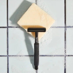 Labeled "KITSCH - SHAVE BUTTER," a black box rests on a cream soap bar with rosemary, shea nuts, and coconut, promoting sustainability and hydration. Features: "Reduces Single-Use Plastic," "Clear Shave," "All Natural," and "Vegan." Package weight is 4 oz (113g).