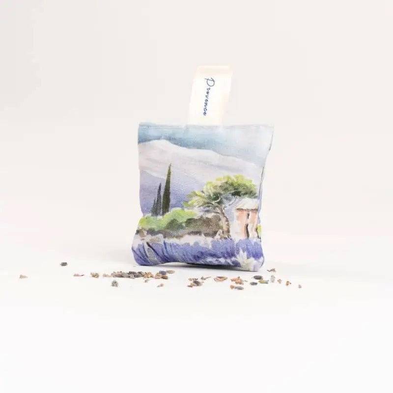The L&#39;AUGUSTE PROVENCE - FRENCH ORGANIC LAVENDER SACHET AND GIFT BOX features artisanal design with painted lavender fields and “Fabriqué en Provence, FRANCE,” creating an authentic Provence gift from L&#39;AUGUSTE PROVENCE.