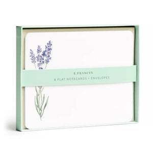 A box of E. FRANCES PAPER's LAVENDER FLAT NOTES, ideal for sharing thoughtful words. The front card displays a delicate watercolor of lavender flowers, while the pastel green packaging features a minimalist design, making it a perfect small gift.