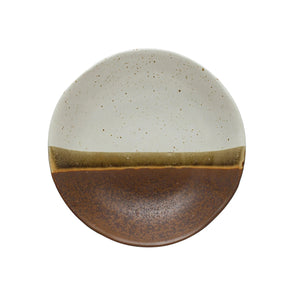 The STONEWARE LOW BOWL IN EARTH TONE REACTIVE GLAZE by CREATIVE COOP features a speckled off-white top, solid brown bottom, and an olive-brown stripe, highlighting handcrafted artistry with a beautiful reactive glaze finish.