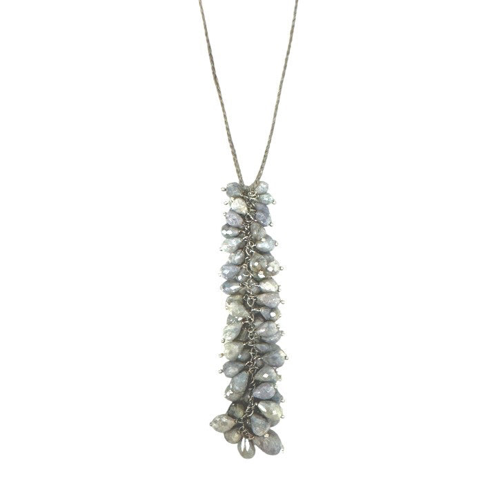 The ANN LIGHTFOOT - COLUMN CLUSTER SILVERITE NECKLACE by ANN LIGHTFOOT features a cascade of grey teardrop-shaped beads, creating a clustered and textured design, hanging from a thin, delicate nylon cord.