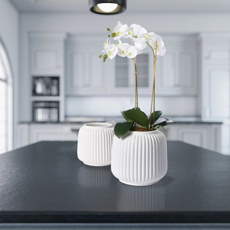 The NAPA HOME AND GARDEN - MILA Cachepot Large is a white, round ceramic vase with an Italian style featuring vertical ridges, a wide top opening, and a smooth finish.