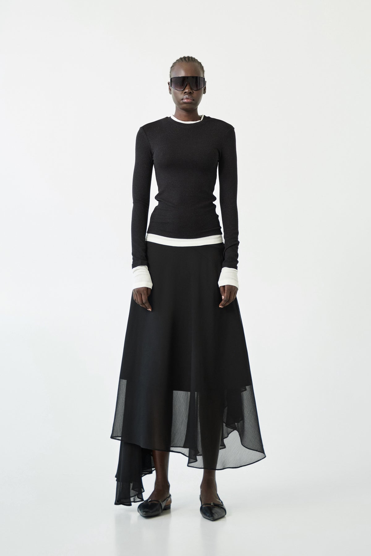 The ELEH - THE CONTRAST LAYER TOP by ELEH is a modern black long-sleeved sweater with white trim on the collar, cuffs, and hem—an effortlessly versatile wardrobe essential shown flat against a white background.
