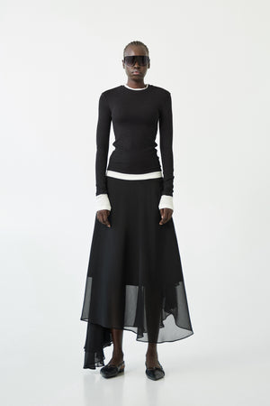 The ELEH - THE CONTRAST LAYER TOP by ELEH is a modern black long-sleeved sweater with white trim on the collar, cuffs, and hem—an effortlessly versatile wardrobe essential shown flat against a white background.