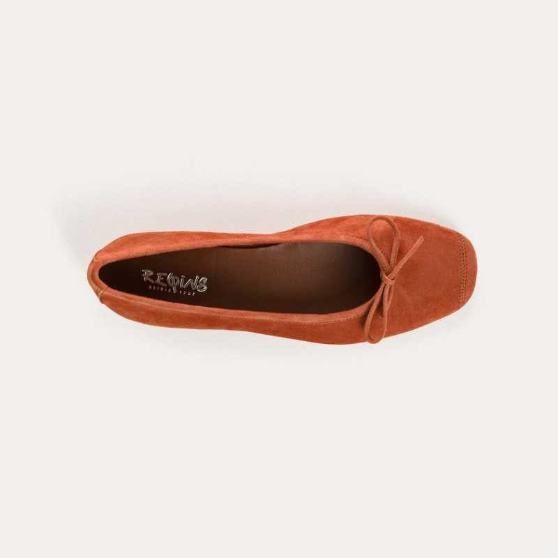 The REQINS - HARMONY Suede Ballerina Flat in Brique is shown in soft suede goatskin with a small bow on the toe, displayed side view against a plain white background.