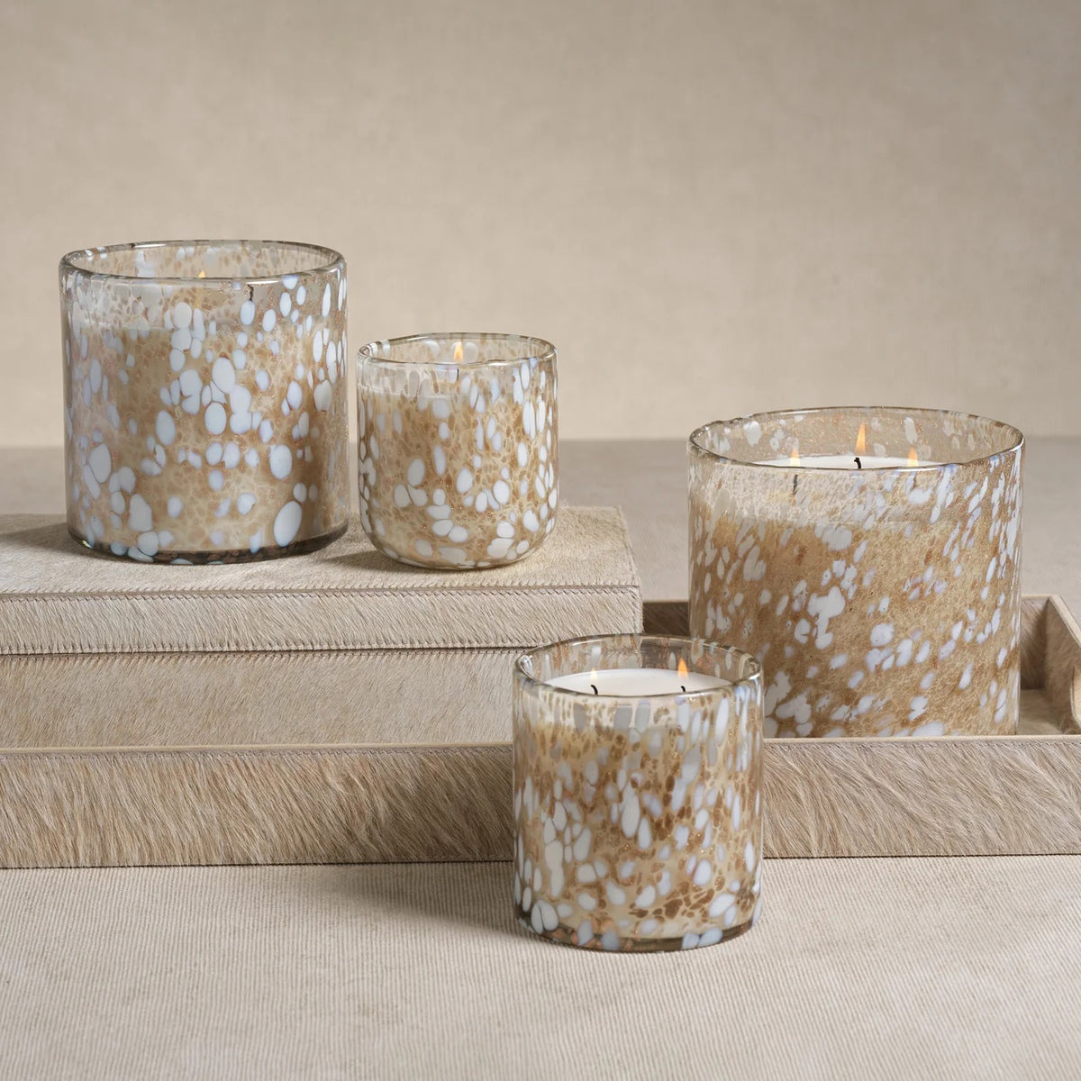 ZODAX TONKA ABSOLUTE SPECKLED LUMIN CANDLE, a three-wick scented candle in a cylindrical glass jar with a brown and white speckled pattern.