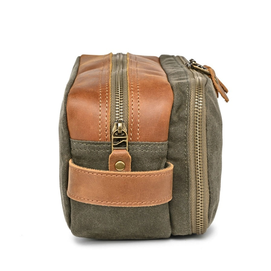 The TSD BRAND Turtle Ridge Toiletry Bag in Olive features leather accents and durable waxed canvas. Grooming essentials fit neatly in elastic loops and mesh pockets, making it the perfect travel companion.