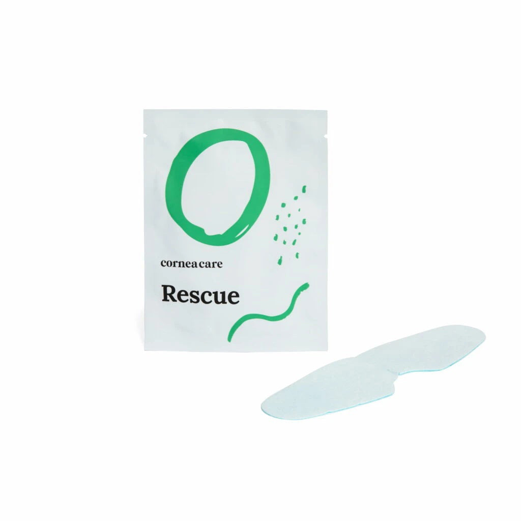A white pouch with green designs reading &quot;CORNEACARE - RESCUE SELF COOLING EYE MASK&quot; by CORNEA CARE is shown next to a light blue, under-eye shaped mask. It offers soothing relief for eye care and dry eyes. The backdrop is plain white.