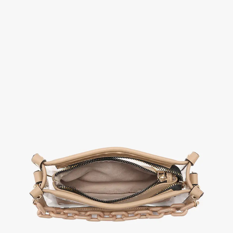 Introducing the CLEAR CROSSBODY BAG by JEN &amp; CO: A stylish handbag crafted from vegan leather, showcasing a layered beige design with an open top and a visible zipper pocket. This bag is elegantly framed by a transparent outer layer and is complemented by a chunky beige chain strap for additional style and versatility.