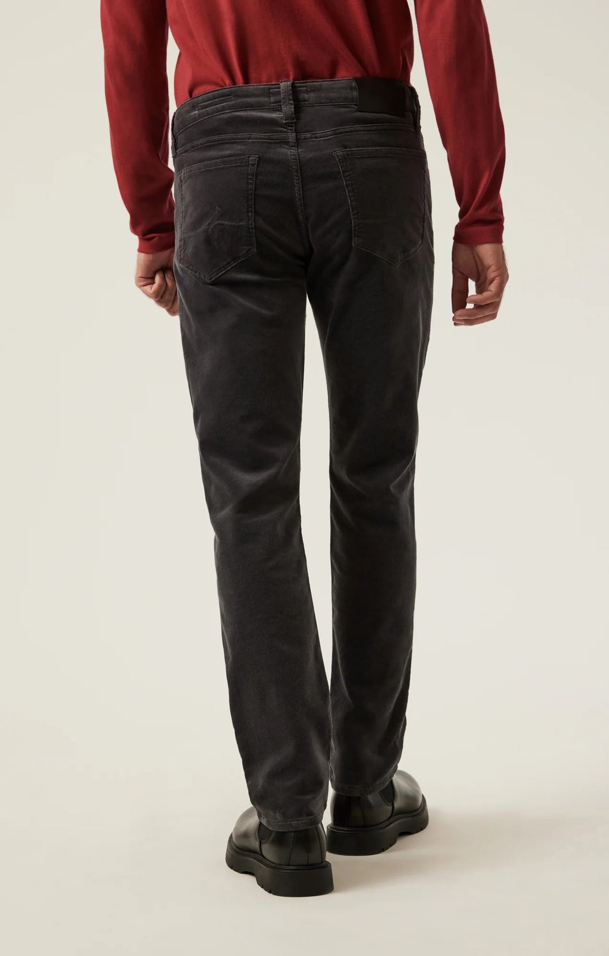 34 HERITAGE - CHARISMA RELAXED STRAIGHT LEG CORDUROY PANTS IN CHARCOAL worn with a red long-sleeve shirt and black leather boots.