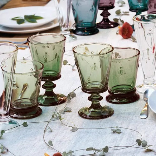 The LA ROCHERE BEE WINE GLASS, OLIVE features embossed bee motifs and an olive hue, inspired by classic Napoleonic stemware, shown on a white background.