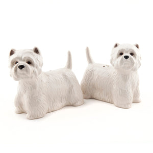 The QUAIL CERAMICS - WESTIE SALT AND PEPPER SET by QUAIL DESIGNS features handpainted stoneware shakers shaped like white West Highland Terriers. Charming and dishwasher safe, they’re displayed side by side on a white background.