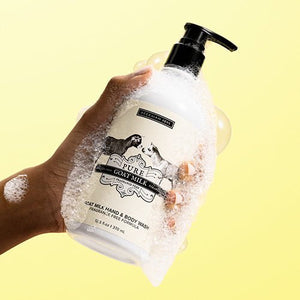 A bottle of BEEKMAN - PURE GOAT MILK HAND & BODY WASH by BEEKMAN - STA ELEMENTS with a white pump dispenser. The label features two goats facing each other and reads "Fragrance Free," "Paraben Free," and "12.5 fl oz / 370 ml." Boasting goat milk prebiotic for skin-healing properties, the vintage design is in classic black and white tones.