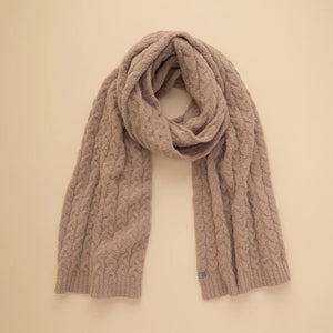 A dark navy blue SOFTIES - CABLE KNIT MARSHMALLOW SCARF draped in a loop.