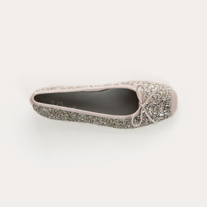 The REQINS HARMONY Sequin Ballerina Flat in Ice features a sparkling design with subtle pink trim and a small bow on the toe, shown from above against a plain light background.