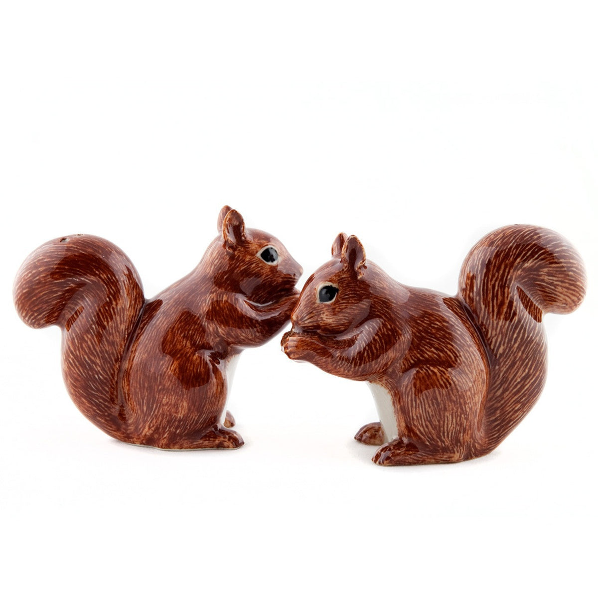 The QUAIL CERAMICS SQUIRREL SALT AND PEPPER shakers from QUAIL DESIGNS feature two handpainted stoneware squirrels with brown fur and white bellies, standing upright and holding food. They're both charming and dishwasher safe.