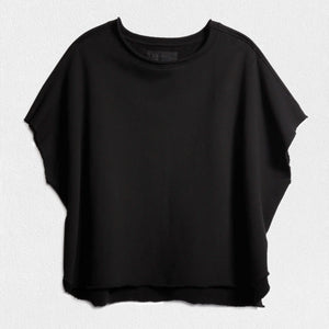 The FRANK & EILEEN OLIVE ORIGINAL CAPELET in black, by FRANK & EILEEN, is a black oversized T-shirt with a round neckline and short, wide sleeves. Made from 100% cotton, it features a loose fit and simple design reminiscent of a capelet against a light textured background.