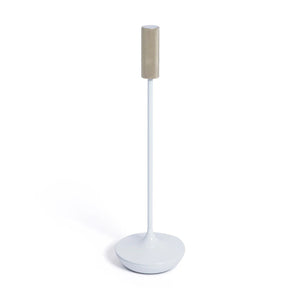 The ZODAX SLEEK RECHARGEABLE TABLE LIGHT, a modern, slim white lamp with adjustable brightness, stands on a festive table with glassware, champagne, chocolates, and gold decor, adding a cozy, celebratory vibe.