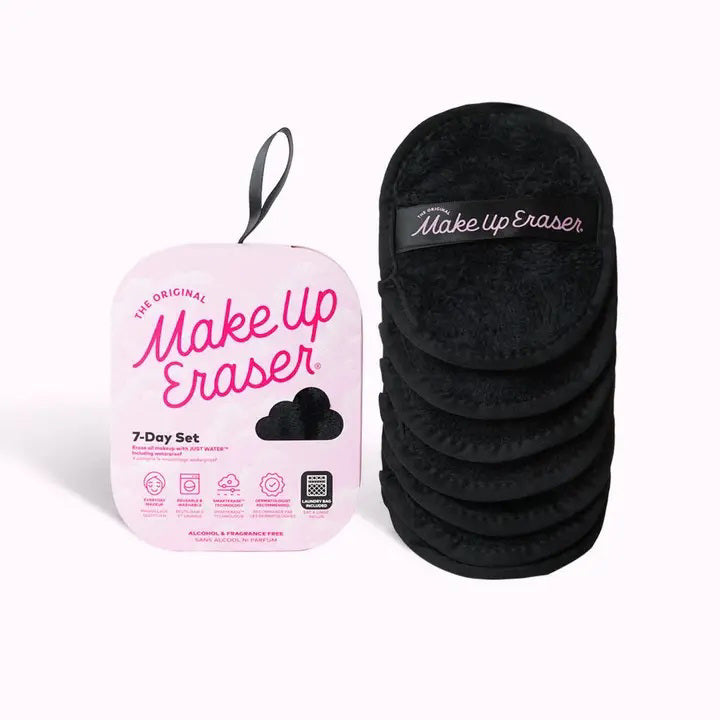 The MAKEUP ERASER CHIC BLACK SEVEN DAY SET from MAKEUP ERASER includes seven black reusable makeup remover pads featuring SmartErase Technology stacked on the right, and the pink storage pouch on the left showcasing the brand name in large pink letters with product information at the bottom.