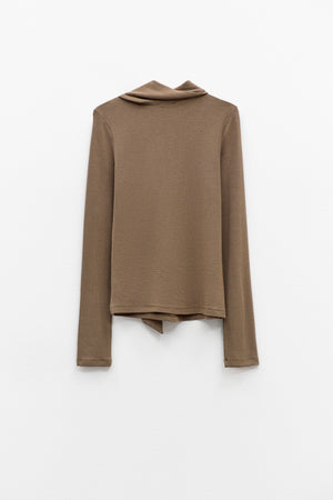 The ELEH - THE SCALA TIE-NECK TOP by ELEH is a light brown, long-sleeved minimalist blouse featuring an asymmetrical attached scarf draped across the front, shown on a hanger against a plain white background.