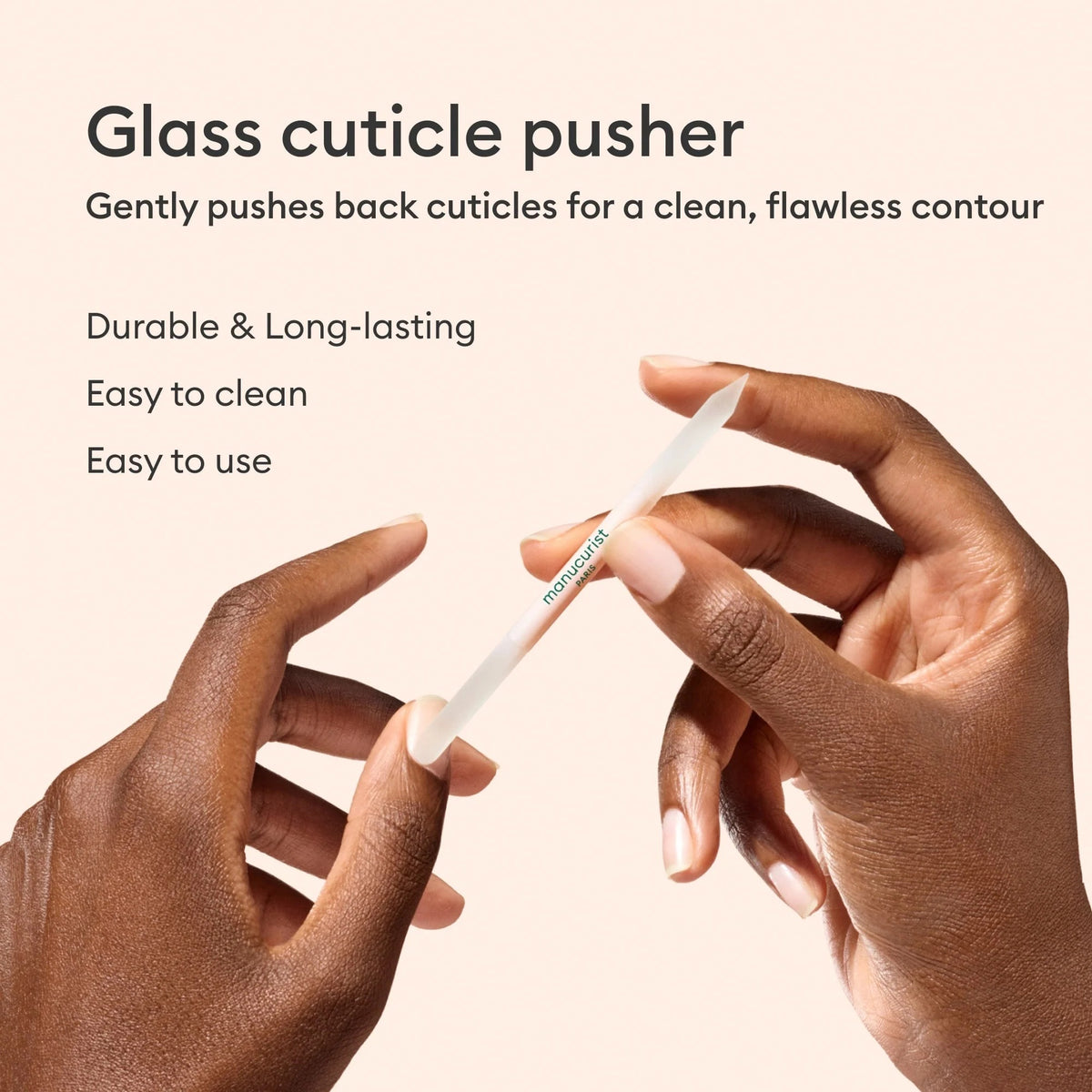 The MANUCURIST - GLASS CUTICLE PUSHER by MANUCURIST INC is a reusable, double-ended white glass cuticle tool with pointed tips and "manucurist PARIS" printed in green at the center, shown on a plain white background.
