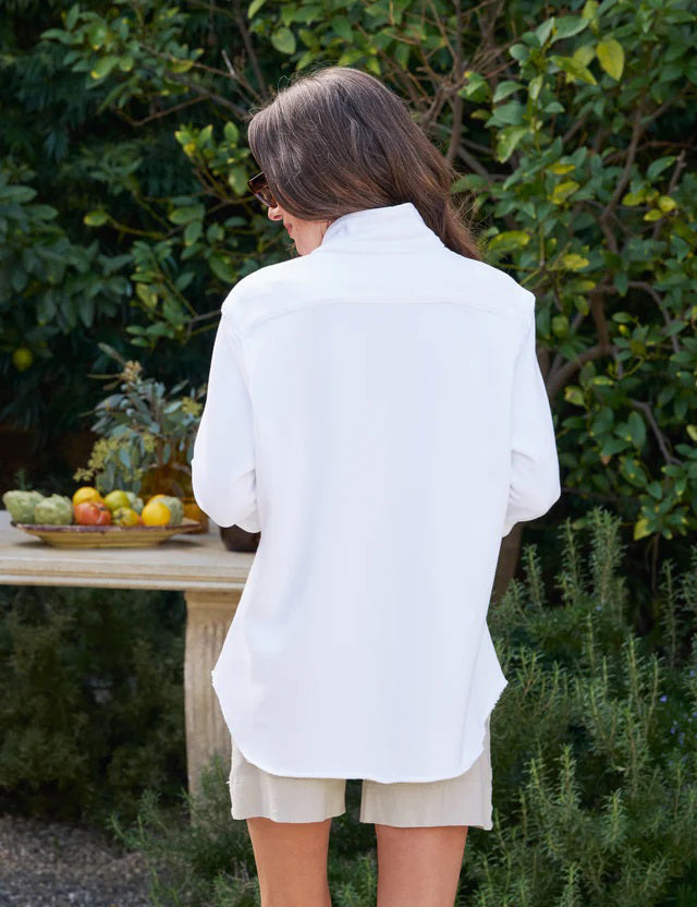 The FRANK AND EILEEN - EILEEN RELAXED BUTTON UP IN TRIPLE FLEECE WHITE features a collared neckline, buttons down the front, and a single chest pocket. The long sleeves are rolled up, and the inside collar label reads &quot;Frank &amp; Eileen EST 1947.&quot; With its relaxed fit and slightly curved hem, it exudes a casual, laid-back vibe.