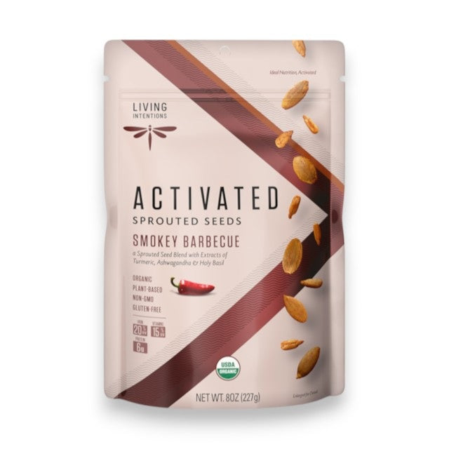 A bag of LIVING INTENTIONS - SMOKEY BARBEQUE SPROUTED SEEDS displays vibrant images of seeds and spices on the front, along with USDA organic, plant-based, and gluten-free labels. This snack from LIVING INTENTIONS features a superfood blend of organic sprouted seeds with a bold smokey barbecue flavor for a wholesome and delicious treat.