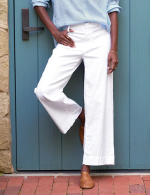 The FRANK AND EILEEN - WEXFORD WIDE LEG LINEN TROUSER IN WHITE from FRANK & EILEEN is a stylish pair of wide-leg pants made from lightweight Italian Performance Linen. These white trousers feature a mid-rise waist, a concealed front zipper, and side pockets, all with a straight and relaxed fit that extends to the hem.