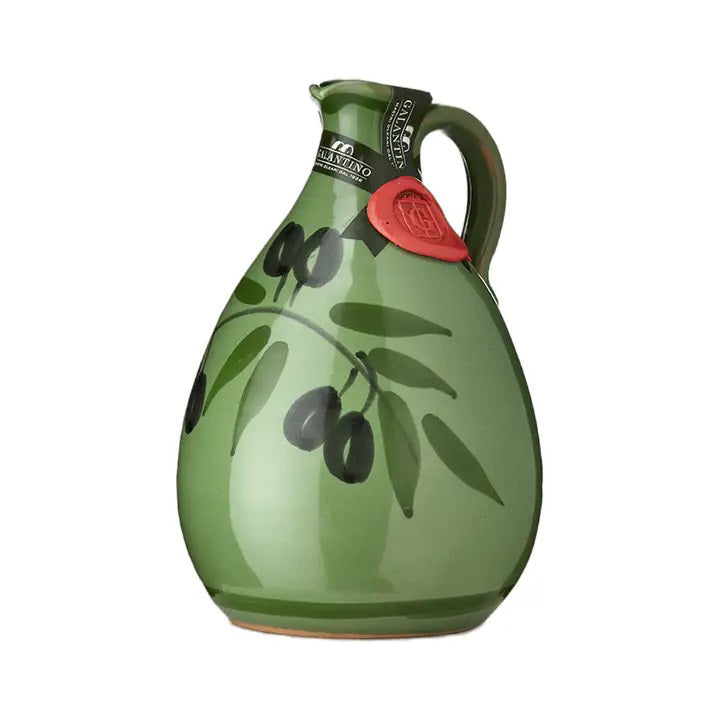 The GALANTINO - TONY EXTRA VIRGIN OLIVE OIL by ZIA PIA IMPORTS is stored in a green hand-painted ceramic jug adorned with black olive designs. The jug features a handle and spout, along with a red wax seal near the top. Ideal for storing liquids, it is perfect for holding extra virgin olive oil from Puglia.