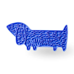 The BARKS & BROWNIES DOGGY LICK MAT - SEA BLUE is a food-grade silicone tray designed in the shape of a dachshund, featuring textured bumps for anxiety relief. Shown from the side against a white background, it’s perfect as a soothing dog lick mat.