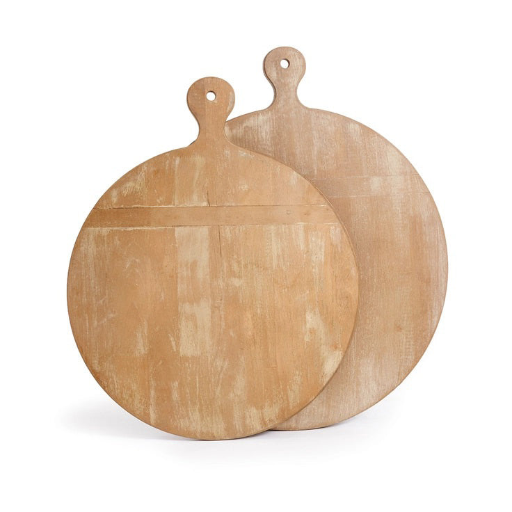 Two light brown Napa Home and Garden antique round cutting boards, featuring a warm gray wash with visible wood grain, are stacked slightly askew. Each has a smooth surface and a small hole in the handle for hanging.