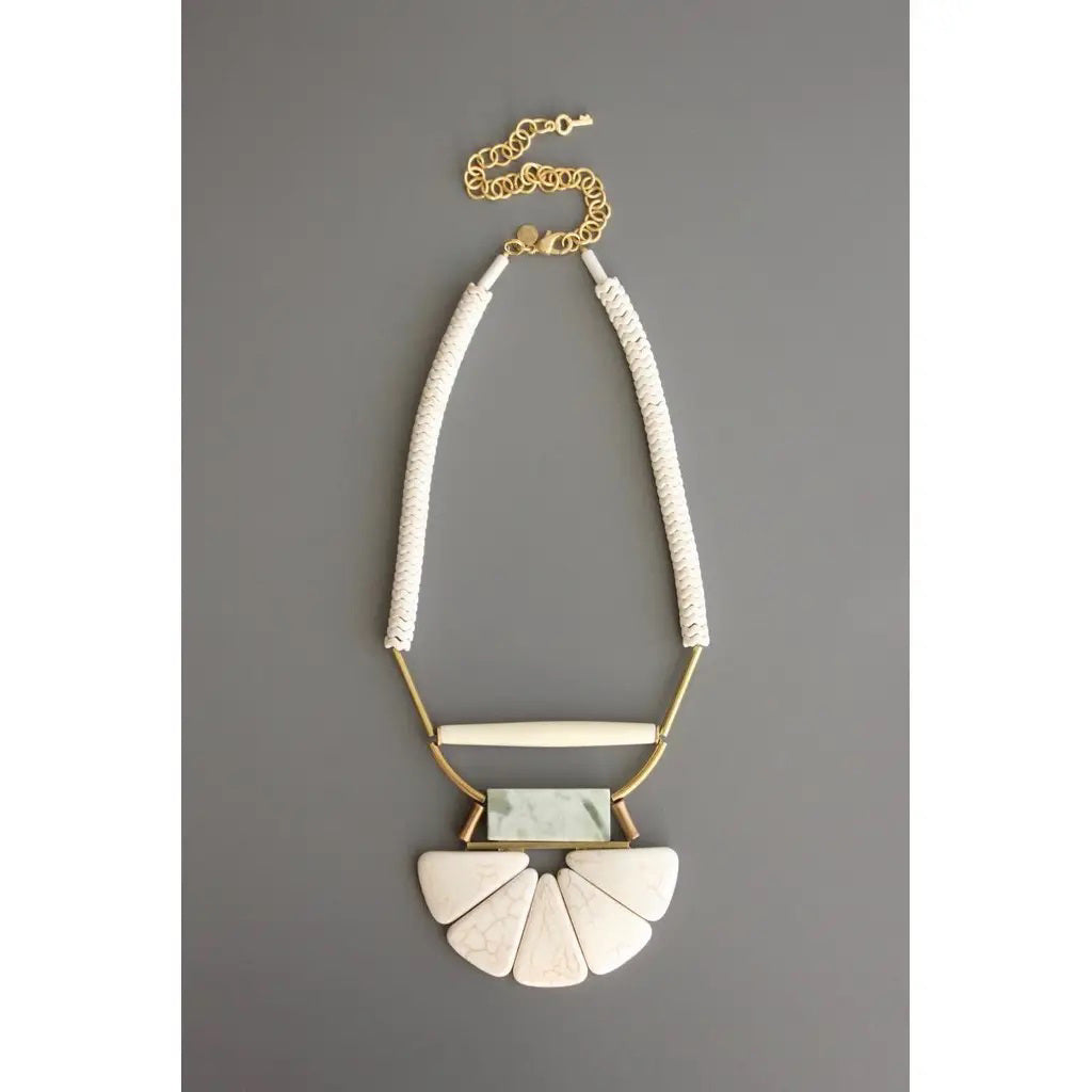 The DAVID AUBREY - WHITE STONE AND JADE LOTUS NECKLACE features five white magnesite pendants with subtle veining, a rectangular jade accent, and metal details—an elegant artisan piece by DAVID AUBREY.