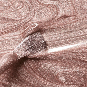 A bottle of MANUCURIST INC GREEN™ Nail Polish in the shade “Cosmic Rose,” showcasing a shimmering rose gold pink hue and topped with a black cap. The label features “green” and “quick dry intense color,” highlighting its vegan and non-toxic formula.