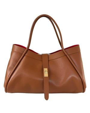 THE PORTICO LEATHER HANDBAG IN COGNAC, a tan suede leather handbag with a central gold-tone turn-lock closure and a bright red interior.