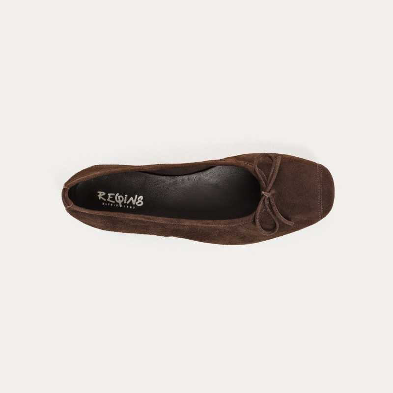 The REQINS HARMONY suede ballerina flats in Marron feature a dark brown finish and a small bow on the toe, shown in side profile against a plain light background—a timeless choice for any classic wardrobe.