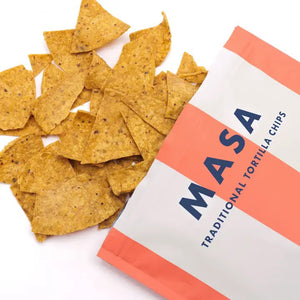A bag of ANCIENT CRUNCH - TRADITIONAL TORTILLA CHIPS by ANCIENT CRUNCH with red and white stripes stands upright, labeled "Original" and "No Seed Oils," highlighting its seed oil-free recipe with crunchy chips scattered in front.