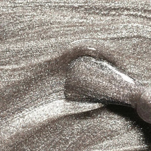 A transparent glass bottle of MANUCURIST - GREEN™ Nail Polish in Disco by MANUCURIST INC contains a sparkling silver glitter vegan polish. The bottle features a black cap and a white label adorned with green and black text.