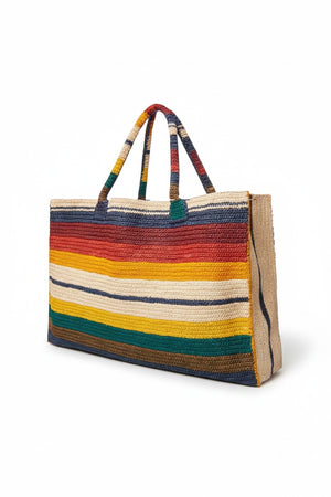 The GABRIELE FRANTZEN LITTLE SISTER WEEKENDER BAG HORIZON features a rectangular shape, handles, and vibrant horizontal stripes in red, yellow, cream, orange, blue, and green on white. This natural fiber bag brightens everyday style.