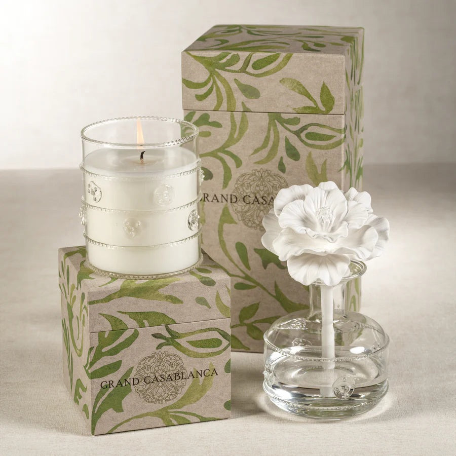 The ZODAX GRAND CASABLANCA CANDLE - WILD TUBEROSE, 12 OZ fills the room with a warm glow and wild tuberose scent in a clear, textured glass holder—perfect for a cozy ambiance or pairing with a botanical gift box.