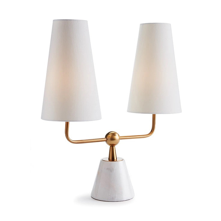 Introducing the Madison Dublet Lamp by NAPA HOME AND GARDEN, showcasing a modern design with two white conical shades on a gold bar. Its marble base and brass finish provide sophistication against a plain white background.
