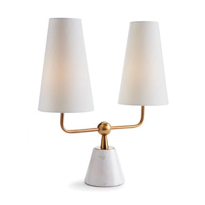 Introducing the Madison Dublet Lamp by NAPA HOME AND GARDEN, showcasing a modern design with two white conical shades on a gold bar. Its marble base and brass finish provide sophistication against a plain white background.