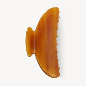 The MACHETE - MIDI HEIRLOOM CLAW by MACHETE is a pink and orange marbled hair claw clip, expertly crafted from premium Italian acetate. It features a curved design, wide grip, and interlocking teeth for a secure hold—ideal for medium volume hair. Shown against a plain white background.