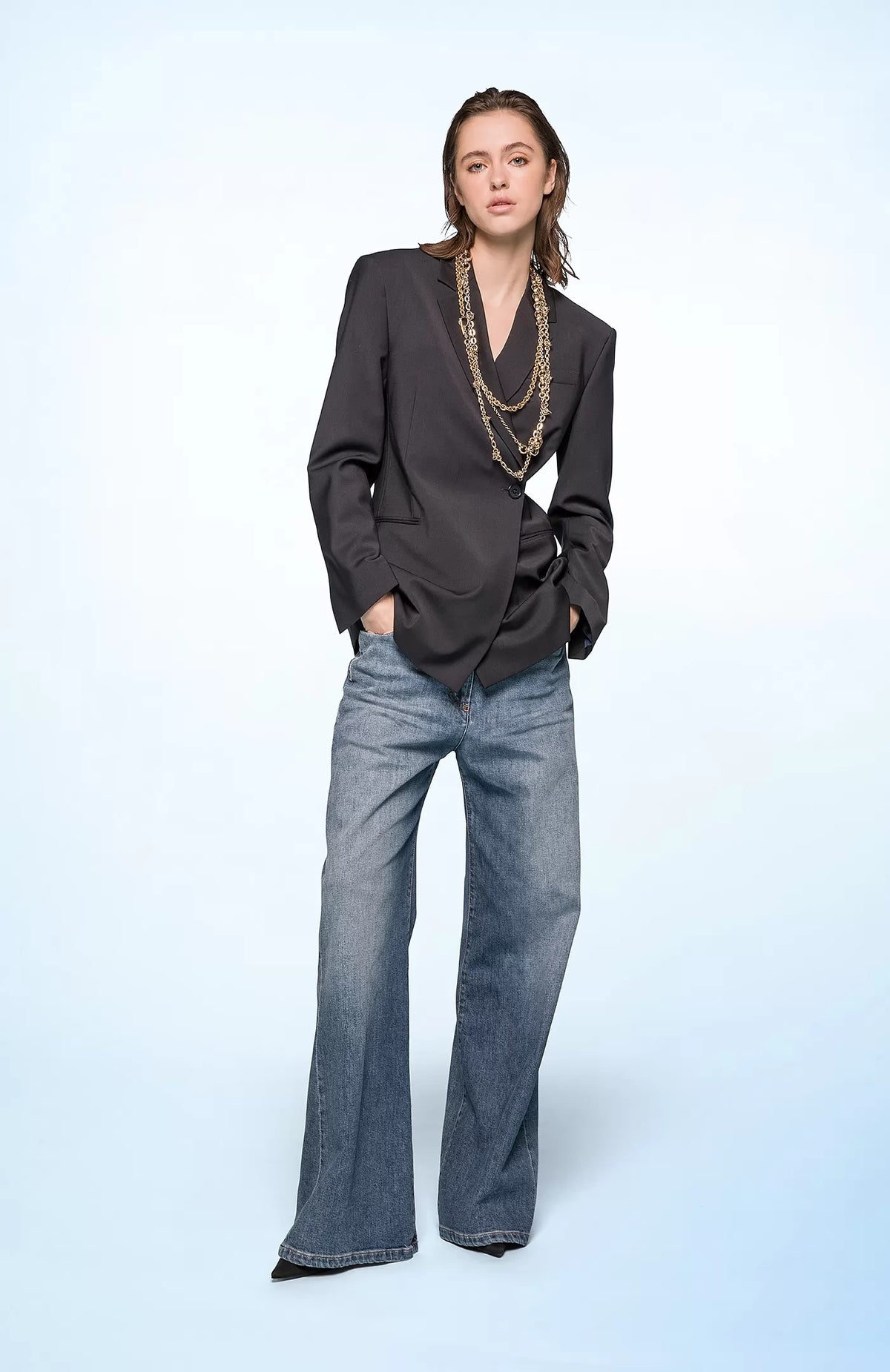 The SEVENTY VENEZIA High-Waisted Wide Leg Jeans from SEVENTY feature a high-waisted design and a wide-leg silhouette. These jeans include front and back pockets, a button and zipper fly closure, and a classic five-pocket design. The denim has a slightly worn, faded appearance.