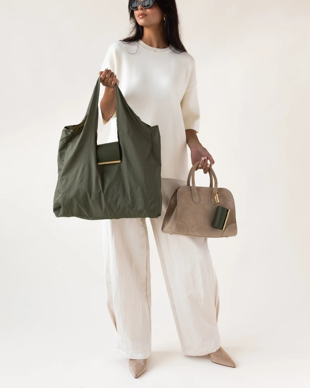 The KEOTE - KEYCHAIN TOTE IN OLIVE by KEOTE is shown flat with a matching foldable case attached to the handle, and a separate rectangular pouch placed at the top right corner.