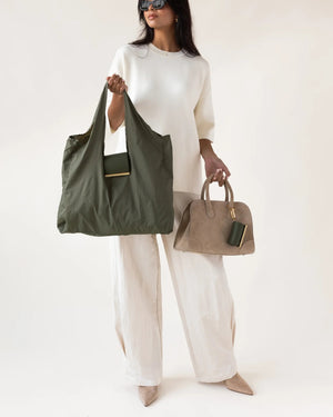 The KEOTE - KEYCHAIN TOTE IN OLIVE by KEOTE is shown flat with a matching foldable case attached to the handle, and a separate rectangular pouch placed at the top right corner.