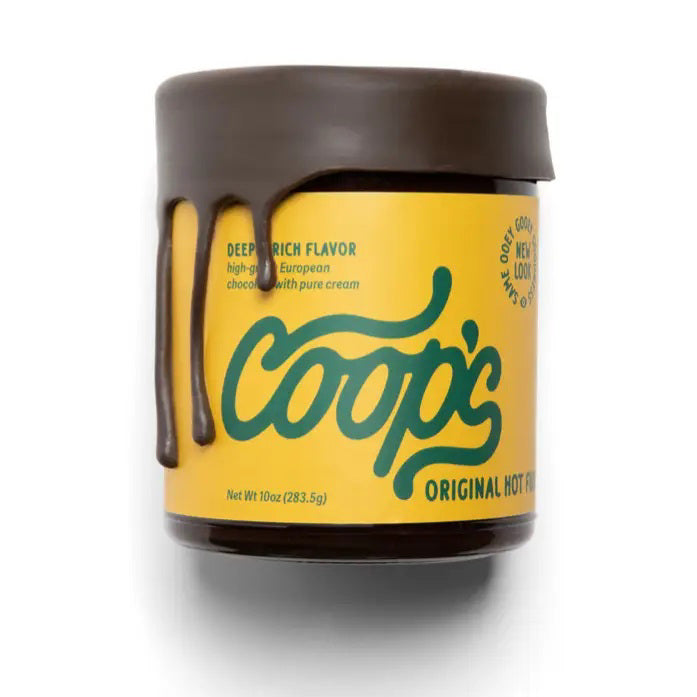 A jar of COOP'S - ORIGINAL HOT FUDGE is displayed with a dark brown lid and yellow label. The lid features a drip effect, resembling fudge oozing down the sides. The label boasts "Deep Rich Flavor, high-quality European chocolate with pure cream." This artisanal treat has a net weight of 10 ounces (283.5g).