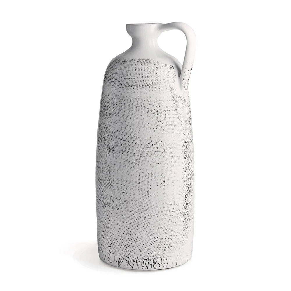 The NAPA HOME AND GARDEN - ENZO JUG is a tall, white ceramic pitcher with a textured cross-hatch pattern and narrow neck, ideal for faux florals. Its small side handle and rustic, artisanal design add elegance to any modern-inspired decor.